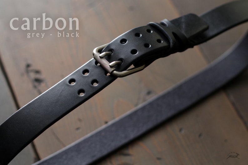 May include: Black leather belt with a silver buckle and multiple rows of holes. The belt is labeled "carbon grey - black".
