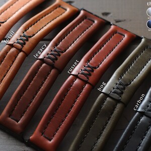 May include: Close-up of six leather watch straps in different colors and textures, including natural, fossil, legacy, russet, bog, and carbon. Each strap has a contrasting thread color and a stitched design. The text "thread option" is displayed above a color chart with the thread colors: white, grey, tan, brown, blue, red, yellow, and black.
