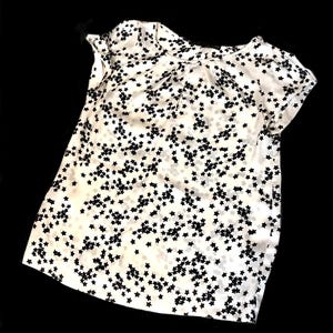 May include: White short-sleeved shirt with a black star print.