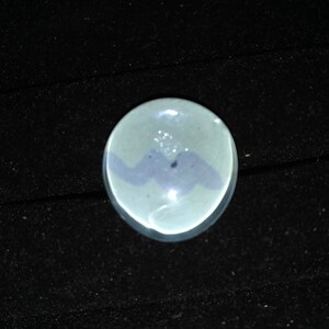 May include: A small, round, white ceramic dish with a blue and white design. The dish has a glossy finish and is perfect for serving small snacks or appetizers.