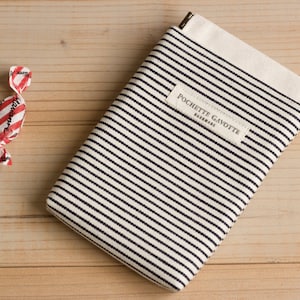 May include: A white and black striped fabric pouch with a small label that reads "POCHETTE GAVOTTE PARISIENNE".