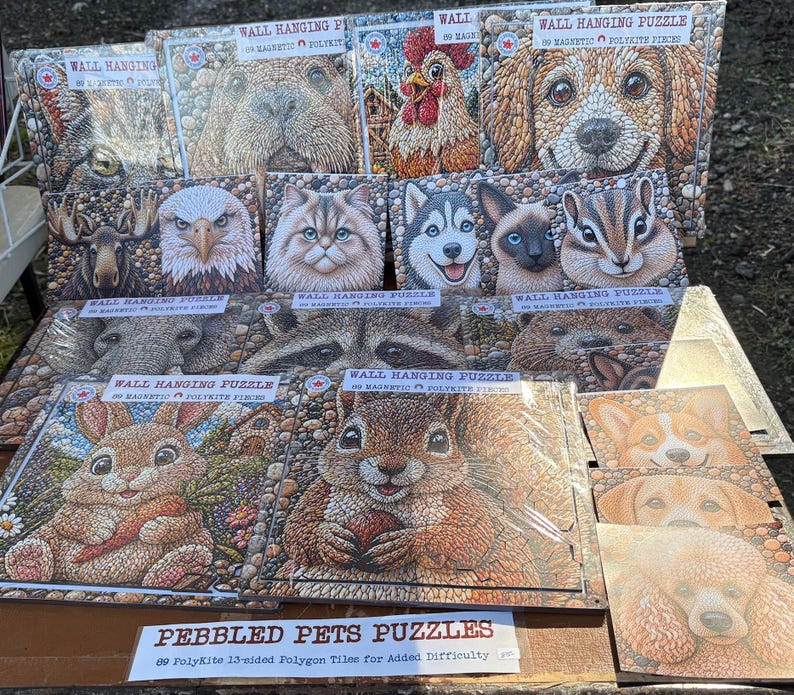 May include: A selection of "Pebbled Pets Puzzles" showing a dog, cat, and squirrel. Each "Wall Hanging Puzzle" contains 89 magnetic tiles. The puzzles have a textured, pebble-like design. The text reads "89 PolyKite 13-sided Polygon Tiles".
