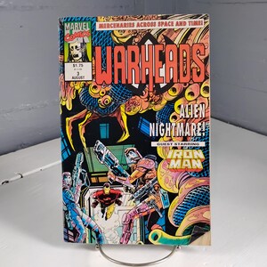 May include: A comic book titled "Warheads" with the Marvel Comics logo. The cover features a vibrant illustration of futuristic soldiers, Iron Man, and an alien creature. The text reads "Alien Nightmare!" and "Guest Starring Iron Man."