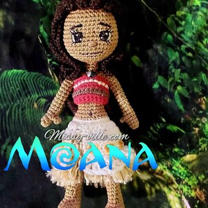May include: Crocheted Moana doll with brown hair, a red and white top, and a white and brown skirt. The doll is standing on a green background with the text "Missy-ville.com MOANA" below it.
