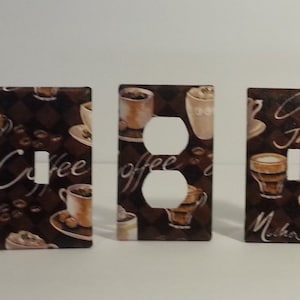 Pode incluir: Conjunto de seis tampas de interruptor de luz decorativas com tema de café. As tampas são marrons com texto branco e imagens de xícaras de café e grãos de café. O texto nas tampas inclui "Mocha", "Coffee", "Java", "Cappuccino" e "Latte".