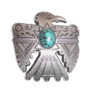 May include: Silver-toned metal pendant featuring a stylized Native American Thunderbird design with a turquoise stone in the center. The pendant has intricate details and a western canteen logo.