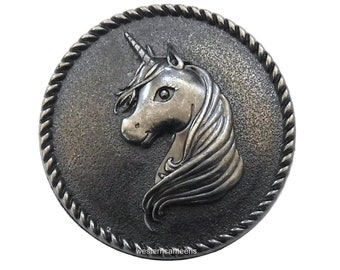 May include: A round, antique silver-colored metal button featuring a detailed unicorn head in profile. The unicorn has a flowing mane and a prominent horn. The button is encircled by a rope-like border, with the text "westerncanteens" at the bottom.