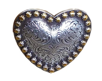 May include: Silver heart-shaped belt buckle with a floral design and gold-colored accents around the edge.