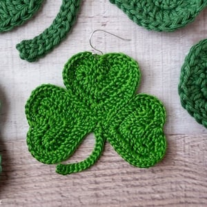 May include: Green crocheted shamrock shaped earrings with a silver hook.