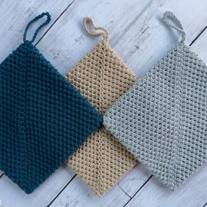 May include: Three crocheted pot holders in teal, beige and grey with a loop handle. The pot holders are made with a textured stitch.