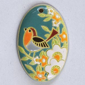 May include: An oval ceramic pendant featuring a teal background with a robin bird illustration. The bird has an orange chest, brown head, and black wing details. The design includes white and orange flowers with light green leaves throughout.