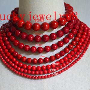 Può includere: Una collezione di collane di perline rosse di varie dimensioni, esposte su un manichino. Le perline variano da 6 mm a 18 mm di diametro, mostrando una sfumatura di dimensioni. Il testo "lucky jewelry" è visibile nell'immagine.