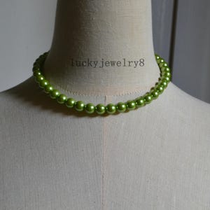 Op de afbeelding: Een groene kralenketting op een mannequin. De ketting heeft ronde, glanzende kralen in een heldere groene kleur. De tekst "lucky jewelry8" is zichtbaar op de mannequin.