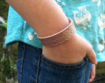 1/2 inch wide diffuser bracelet for aromatherapy - natural leather tooled with a repeating floral design and sealed with pearl topcoat