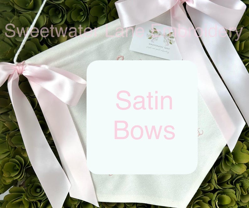 May include: White fabric banner with pink satin bows and the text "Satin Bows" in pink lettering.