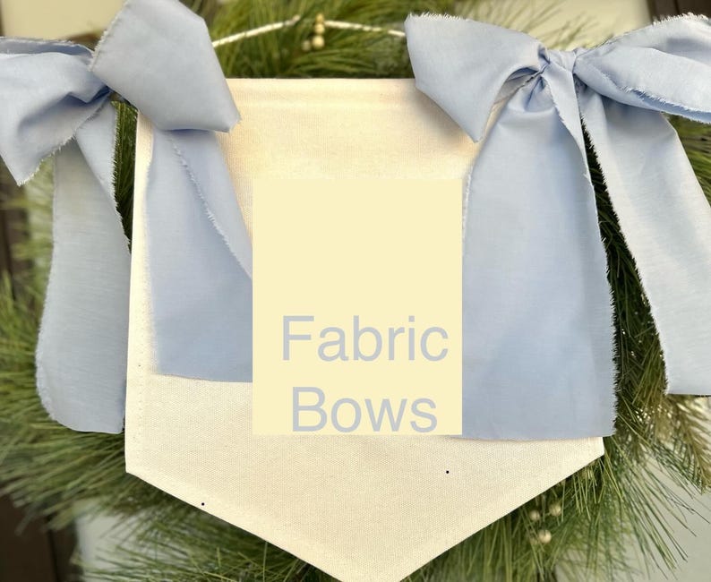 May include: A white fabric banner with the text "Fabric Bows" in light blue lettering. The banner is decorated with two large, light blue fabric bows.