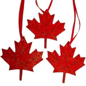 May include: Three red glitter maple leaf ornaments with red ribbon hangers.
