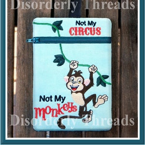 May include: A light blue zippered pouch with the text "Not My Circus" and "Not My Monkeys" embroidered in red and black. A cartoon monkey is embroidered on the pouch, hanging from a vine.