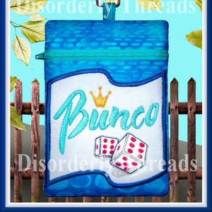 May include: A blue zippered pouch with a white panel featuring the word "Bunco" in teal script, a gold crown, and dice. The pouch has a teal zipper and a silver clip.