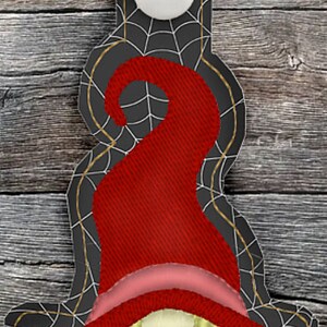 May include: A red and black witch gnome keychain with a spiderweb design. The gnome is wearing a red hat and a red dress with a black lace-up bodice. The gnome has long blonde hair.