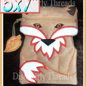 May include: A brown felt fox-shaped zipper pouch with a white and red embroidered fox face and a white tail. The pouch is 5x7 inches and has the text "Discernly Threads" embroidered on the bottom.