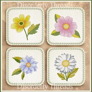 Può includere: Quattro disegni di fiori ricamati su uno sfondo bianco con un bordo verde. I fiori sono gialli, rosa, blu e bianchi.