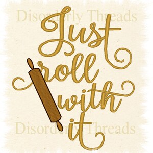 May include: Gold embroidered text on a beige fabric background reads "Just roll with it" with a brown rolling pin illustration.