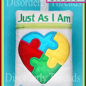 May include: White zippered pouch with a heart-shaped puzzle piece design in red, blue, green, and yellow. The pouch reads "Just As I Am" and "Autism Awareness" in green embroidery. The pouch measures 6x8.5 inches.