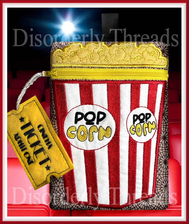 May include: Red and white striped popcorn bucket with a yellow zipper and a yellow popcorn lid. The bucket has two white circles with the text "Pop Corn" in black and yellow. A yellow ticket with the text "Cinema Ticket Admit One" is attached to the bucket.