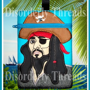 Pode incluir: Uma bolsa azul com zíper com uma imagem bordada de um pirata com um tapa-olho preto, uma bandana vermelha e um chapéu marrom. O pirata tem uma barba preta e cabelo longo e preto. A bolsa é cercada por folhas de palmeira verdes.