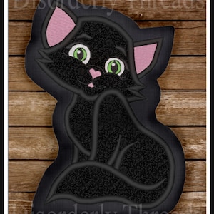 May include: Black cat with green eyes and pink ears, sitting with its tail curled around its body. The cat is embroidered on a brown wooden background.