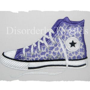 May include: Purple and white leopard print high-top sneakers with a white star logo. The shoes have white laces and a white rubber sole.