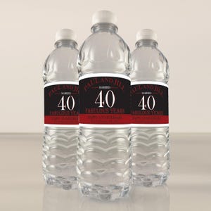 May include: Three clear plastic water bottles with black and red labels that say "Paul and Jill Married 40 Fabulous Years Happy Anniversary".