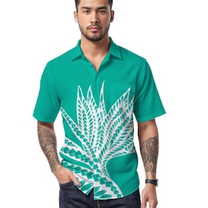 May include: A teal short-sleeve button-down shirt with a white graphic design. The shirt has a front pocket and is paired with dark blue jeans and black shoes. The text "AYELETFLEMING.COM ALL RIGHTS RESERVED." is at the bottom.