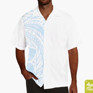 May include: White short-sleeve shirt with a light blue patterned design on the left side. The shirt has a classic collar and button-down front. The design features a series of curved lines and shapes. The shirt is made of a lightweight fabric.