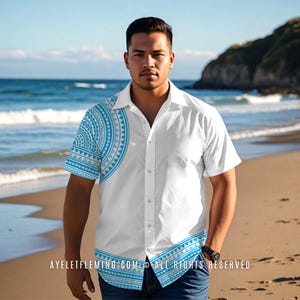May include: White button-down shirt with short sleeves, featuring a blue and white tribal pattern on the left sleeve and bottom hem. The shirt is worn by a person on a beach with the ocean in the background. The text "AYELETFLEMING.COM © ALL RIGHTS RESERVED." is visible.