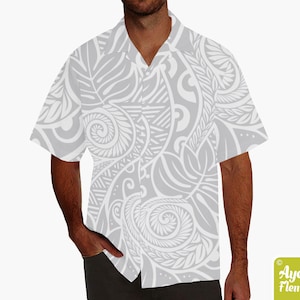May include: A gray short-sleeved button-up shirt with a white Polynesian-inspired pattern. The shirt has a collar and a button-up front.