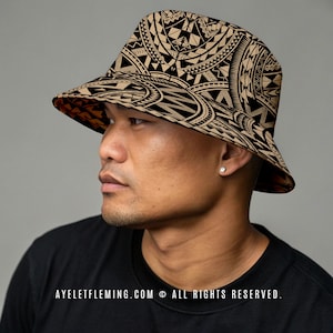 May include: A tan and black patterned bucket hat. The hat features a detailed geometric design. The brim is lined with a contrasting orange fabric. The hat is worn by a person. The text "AYELETFLEMING.COM © ALL RIGHTS RESERVED." is visible.