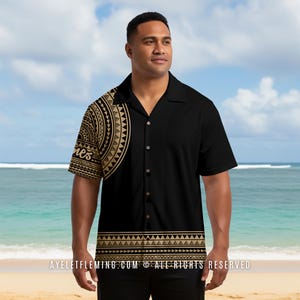 May include: Black button-down shirt with a gold and black tribal pattern on the left shoulder and bottom hem. The shirt has short sleeves and a classic collar. The background shows a beach and blue sky.