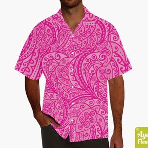 May include: A pink short-sleeved button-down shirt with a white and pink paisley pattern.