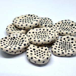 Puede incluir: Un juego de tres tazas de cerámica con un acabado mate moteado. Cada taza presenta un color diferente: azul claro, crema y gris. Las tazas tienen un diseño simple y moderno y un asa cómoda.