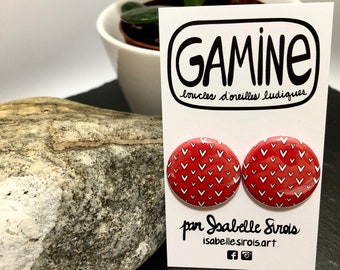Round ear studs illustrated with whit hearts on a red background