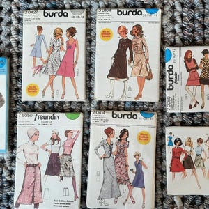 Pode incluir: Uma coleção de pacotes de padrões de costura vintage da Burda e Freundin. Os pacotes apresentam ilustrações de designs de roupas, incluindo vestidos, saias e casacos. Os pacotes são de vários tamanhos e cores, com texto em inglês e alemão.