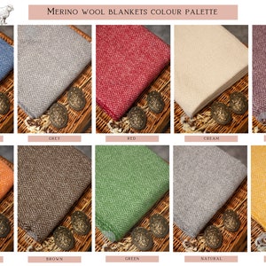K&ouml;nnte beinhalten: Farbpalette von Merino-Woll-Decken in verschiedenen Farben, darunter Blau, Grau, Rot, Creme, Lila, Orange, Braun, Gr&uuml;n, Natur und Gelb. Jede Decke ist gefaltet und auf einer gewebten Oberfl&auml;che pr&auml;sentiert.