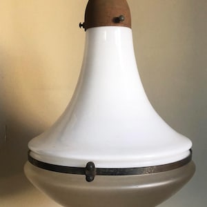 Op de afbeelding: Vintage witte glazen hanglamp met een bruine metalen bovenkant en een matglazen bodem. De lamp heeft een klokvormig ontwerp en een donkere metalen band aan de onderkant. Een klassieke lamp.