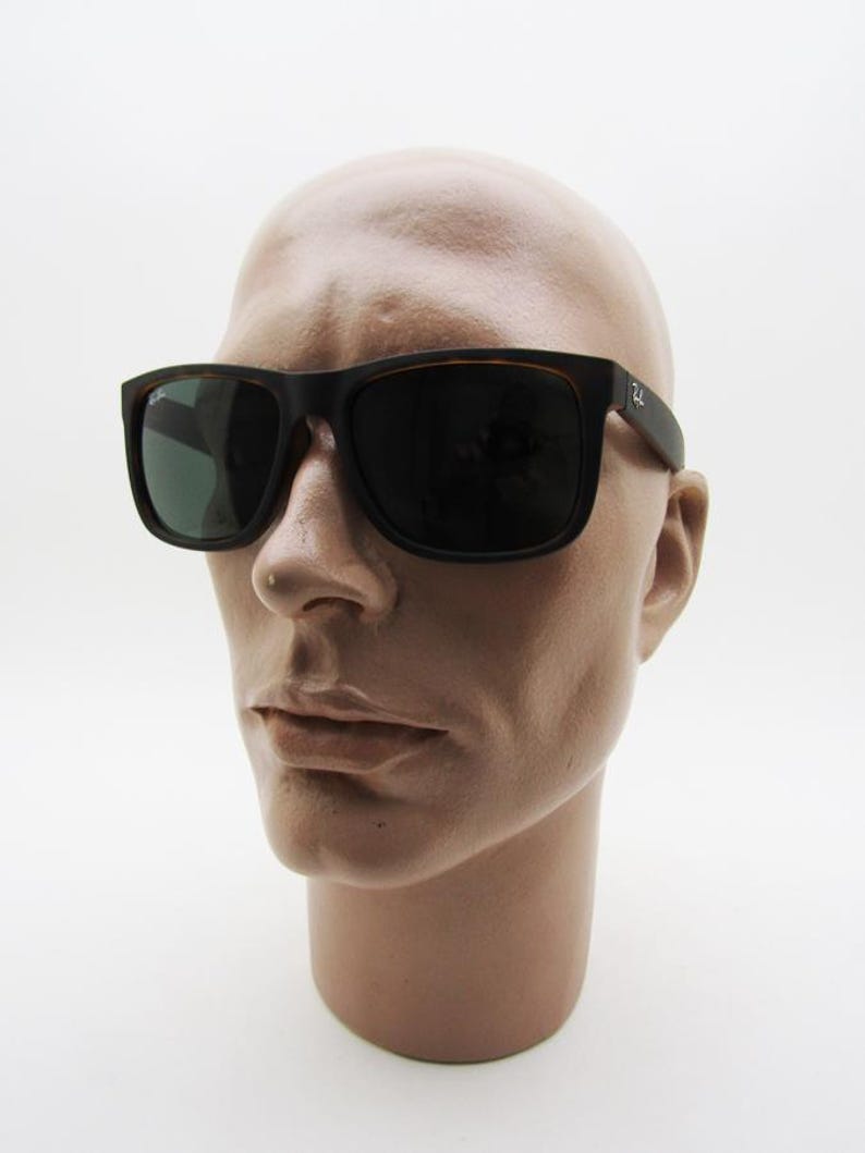 Puede incluir: Gafas de sol cuadradas negras con lentes oscuras. Las gafas de sol tienen un patr&oacute;n de carey marr&oacute;n en la montura interior y las patillas. El logotipo de Ray-Ban es visible en la patilla derecha. Las gafas se muestran en una cabeza de maniqu&iacute;.