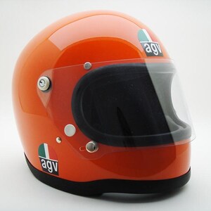 May include: Glossy orange motorcycle helmet with a clear visor and black interior. Features the "agv" logo in white on a green, white, and red background. The helmet has a black base and silver hardware.
