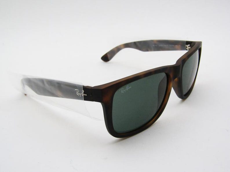 Puede incluir: Gafas de sol marrones y negras con lentes verdes. Las gafas tienen una montura rectangular y un patr&oacute;n de carey en las patillas. El logotipo de Ray-Ban es visible en la lente y la patilla.