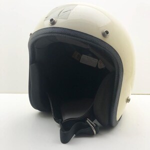 Pode incluir: Capacete de motocicleta vintage creme com interior e acabamento preto. O capacete tem um acabamento brilhante, rebites de metal e uma tira de queixo preta com fivela de metal. Há um pequeno pedaço de fita adesiva na parte superior.