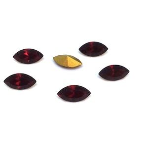 Peut inclure: Six strass de forme marquise de couleur marron et un strass de couleur or.